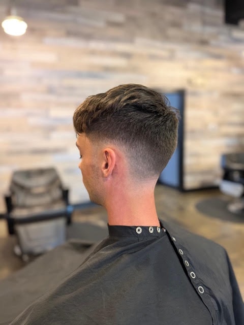 Fresh taper fade haircut with the barbershop behind